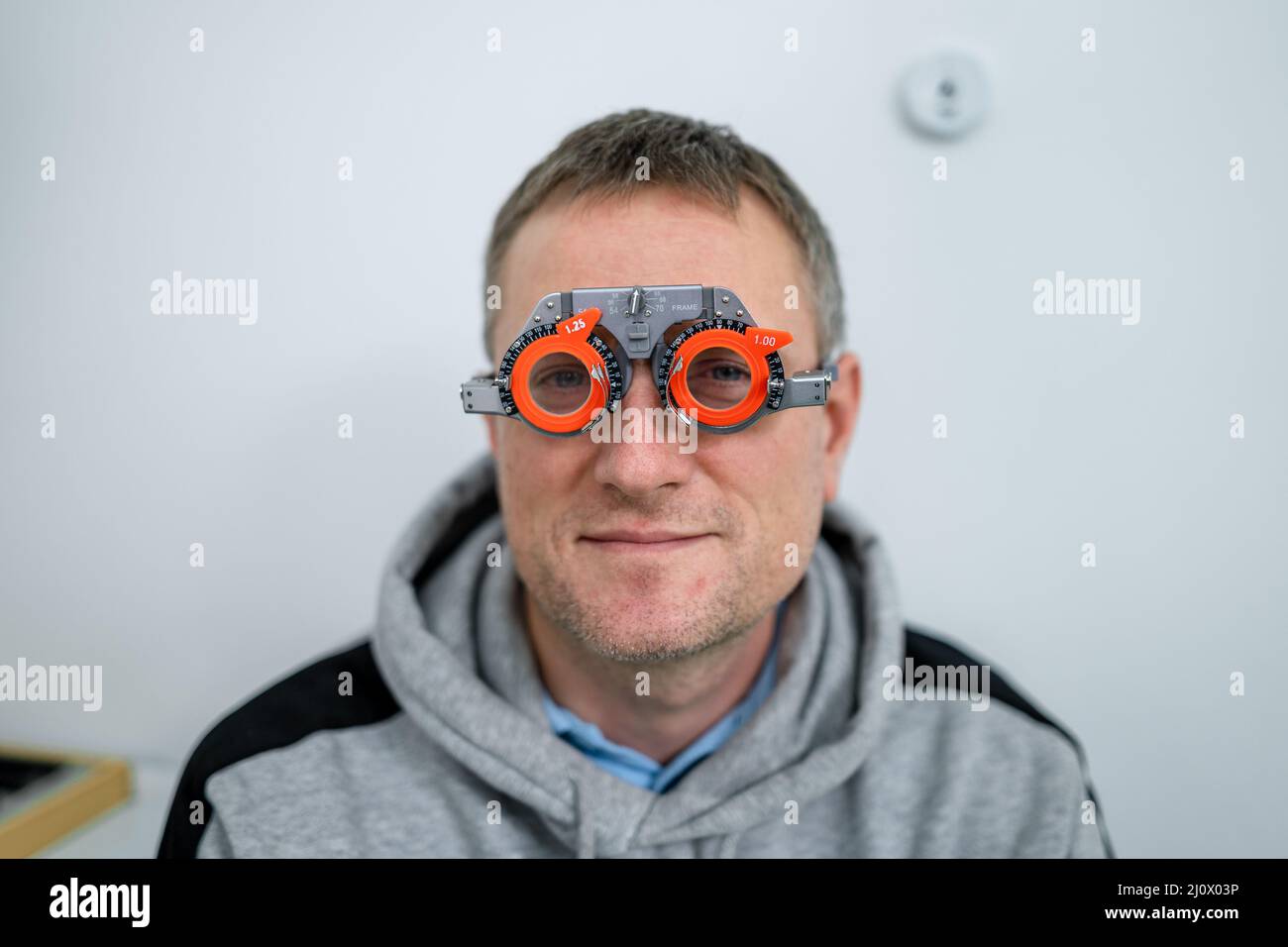 Correzione della visione. Selezione di occhiali. Montature di prova  professionali sul viso del paziente maschile mentre il medico controlla la  vista in MODER Foto stock - Alamy
