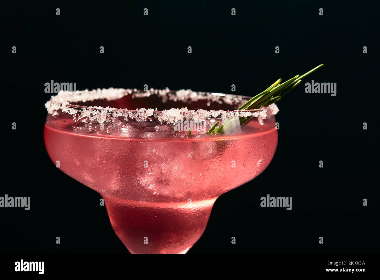 Cocktail di rosmarino alcolico o non alcolico come margarita, cosmopolita o simile su un tavolo di marmo scuro Foto Stock