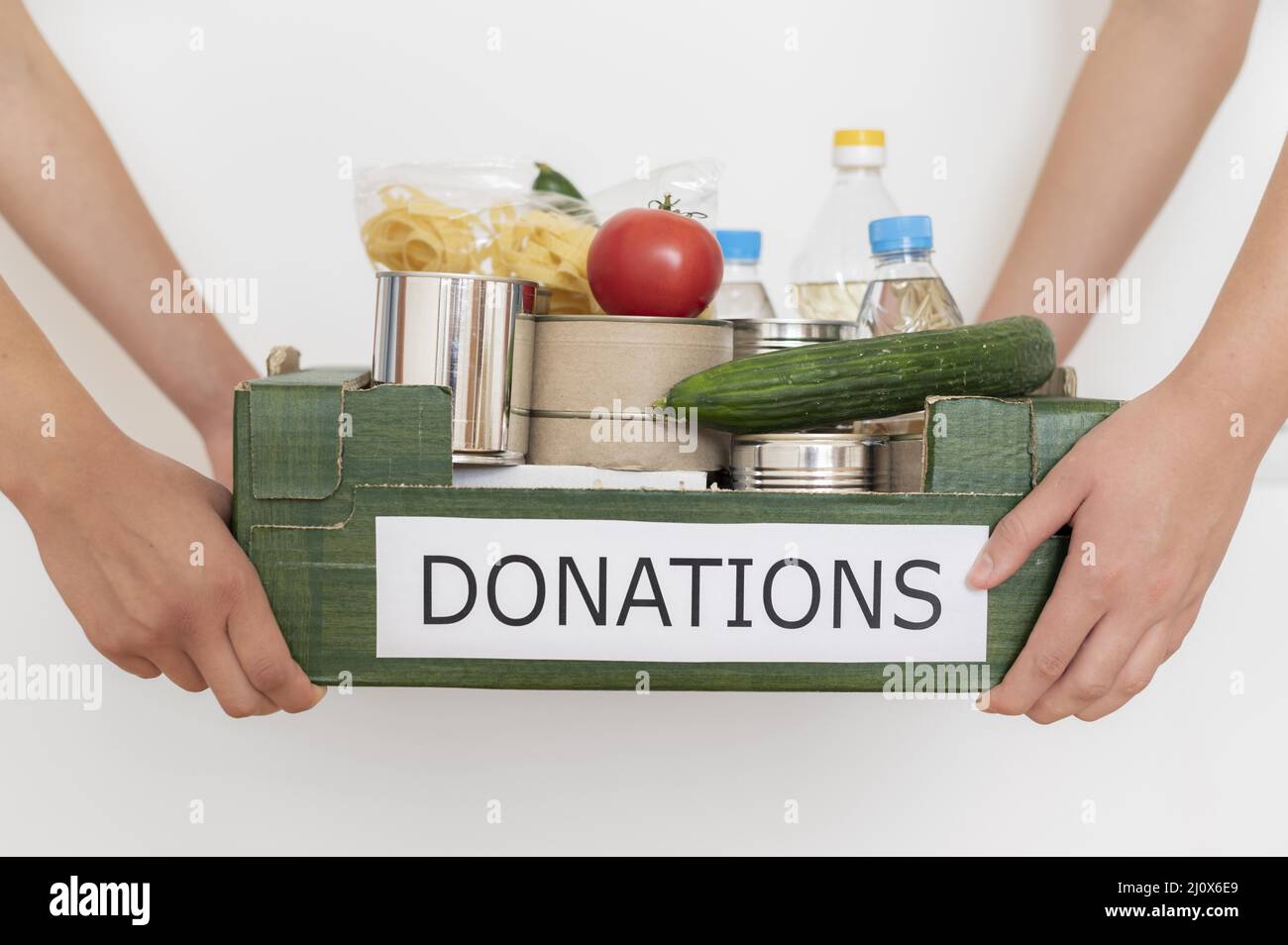 I volontari che detengono una scatola piena di donazione di cibo. Concetto di foto di alta qualità Foto Stock