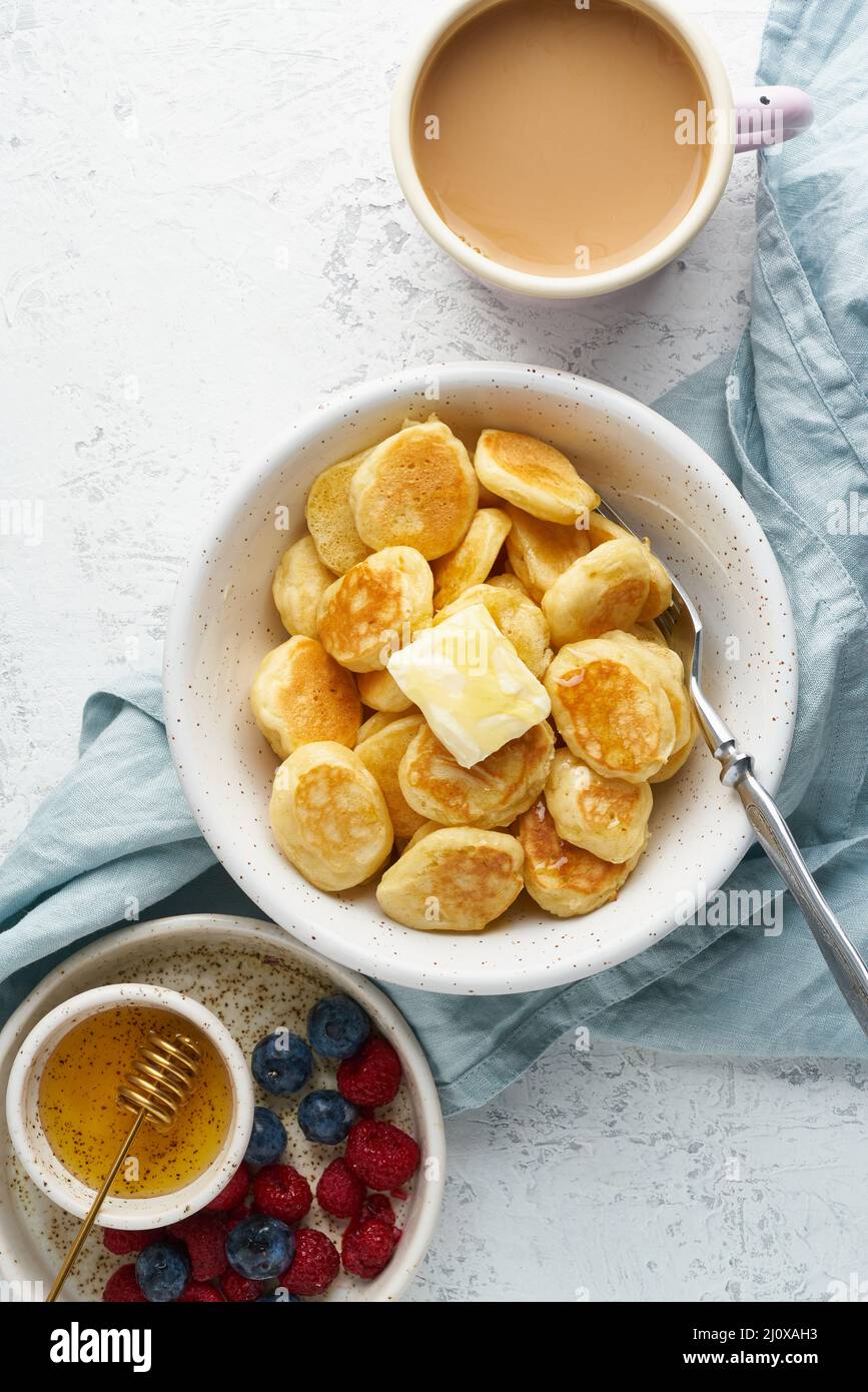 Pancake cereali, minuscoli e sottili briciole divertenti, cibo per bambini. Colazione con drink Foto Stock