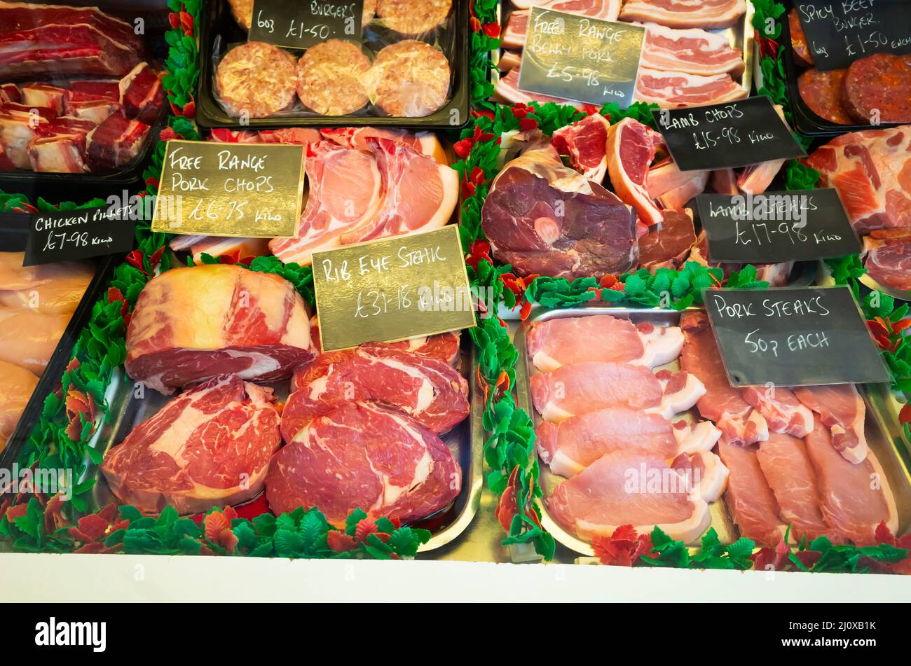 Macellaio vetrata a Saltburn North Yorkshire Inghilterra UK con un'esposizione di molti tipi di carne preparata con i prezzi di marzo 2022 Foto Stock