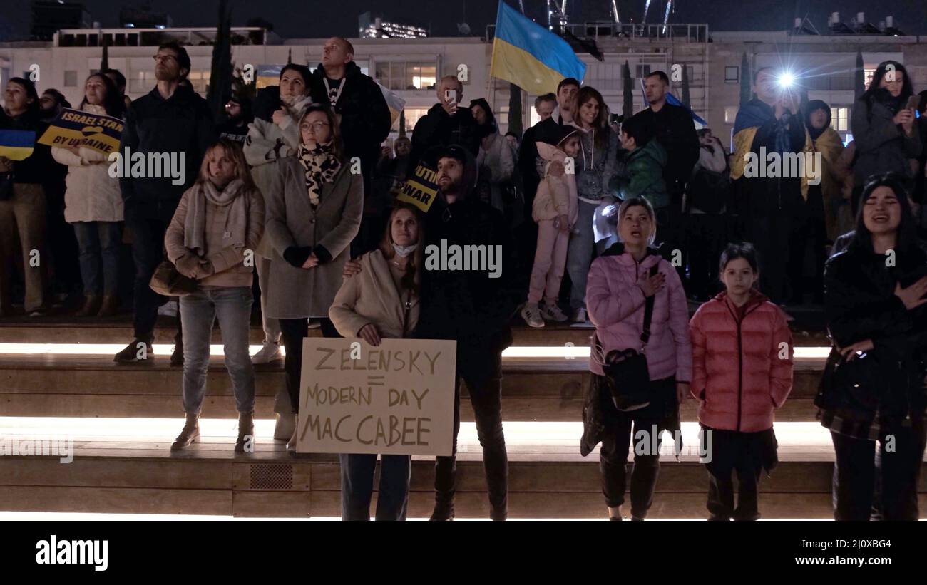 Tel Aviv, Israele. 20th Mar 2022. I manifestanti cantano l'"inno di Stato dell'Ucraina", l'inno nazionale dell'Ucraina, mentre si riuniscono per guardare un video discorso del presidente ucraino Volodymyr Zelensky al parlamento israeliano trasmesso a Piazza Habima il 20 marzo 2022 a Tel Aviv, Israele. Zelensky ha chiesto ad Israele di imporre sanzioni alla Russia e di aiutare l'Ucraina, ricordando la Germania nazista e confrontando le sue azioni con la situazione attuale. Credit: Eddie Gerald/Alamy Live News Foto Stock