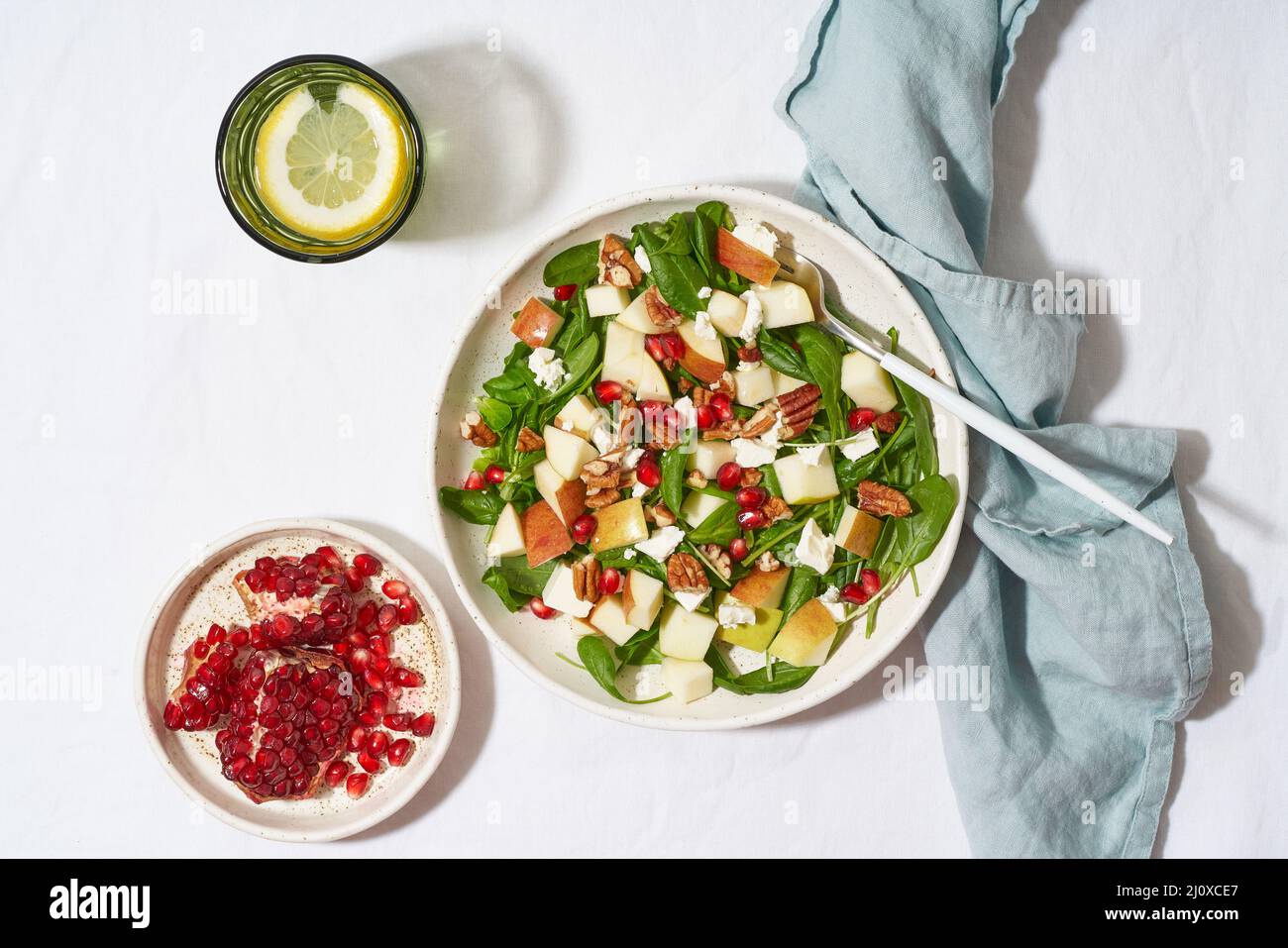 Macedonia di frutta con Spinach con mele, noci pecan e feta. Luce intensa, ombre, vista dall'alto Foto Stock