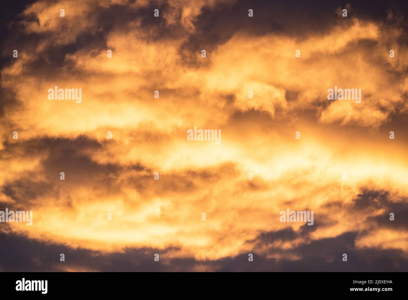 Vista ravvicinata di spettacolari e colorate nuvole di cumulo soffice sul cielo blu sullo sfondo del tramonto Foto Stock