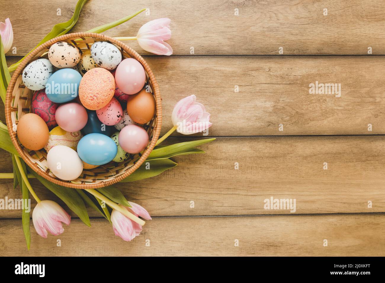 Tulipani intorno ciotola con uova Foto Stock