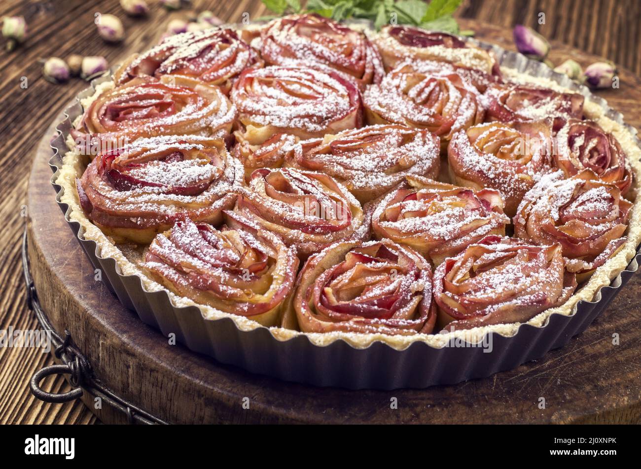 Tradizionale francese torta di mele aux pommes bouquet de rose servito come primo piano in classico piatto di supporto Foto Stock