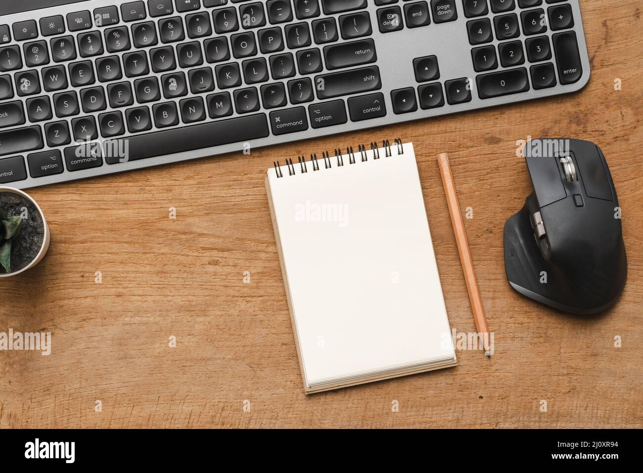 Tavolo da scrivania in legno con taccuino bianco con matita, computer e accessori Foto Stock