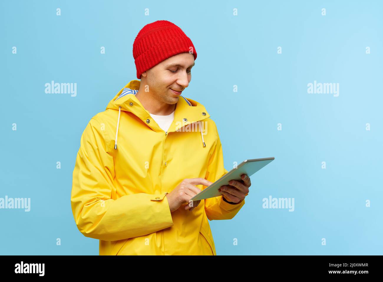 Ritratto di positivo fresco uomo in caldo autunno top esterno vestiti che tengono la compressa Foto Stock