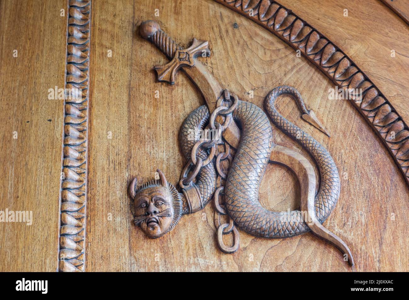 Serpente diavolo simbolo. Fantasia creatura magica su una vecchia porta, 12th secolo Abbazia in Italia. Foto Stock