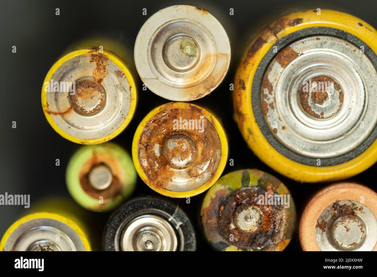 Primo piano della batteria usata con tracce di ruggine e corrosione. Concetto di rifiuti pericolosi elettronici Foto Stock