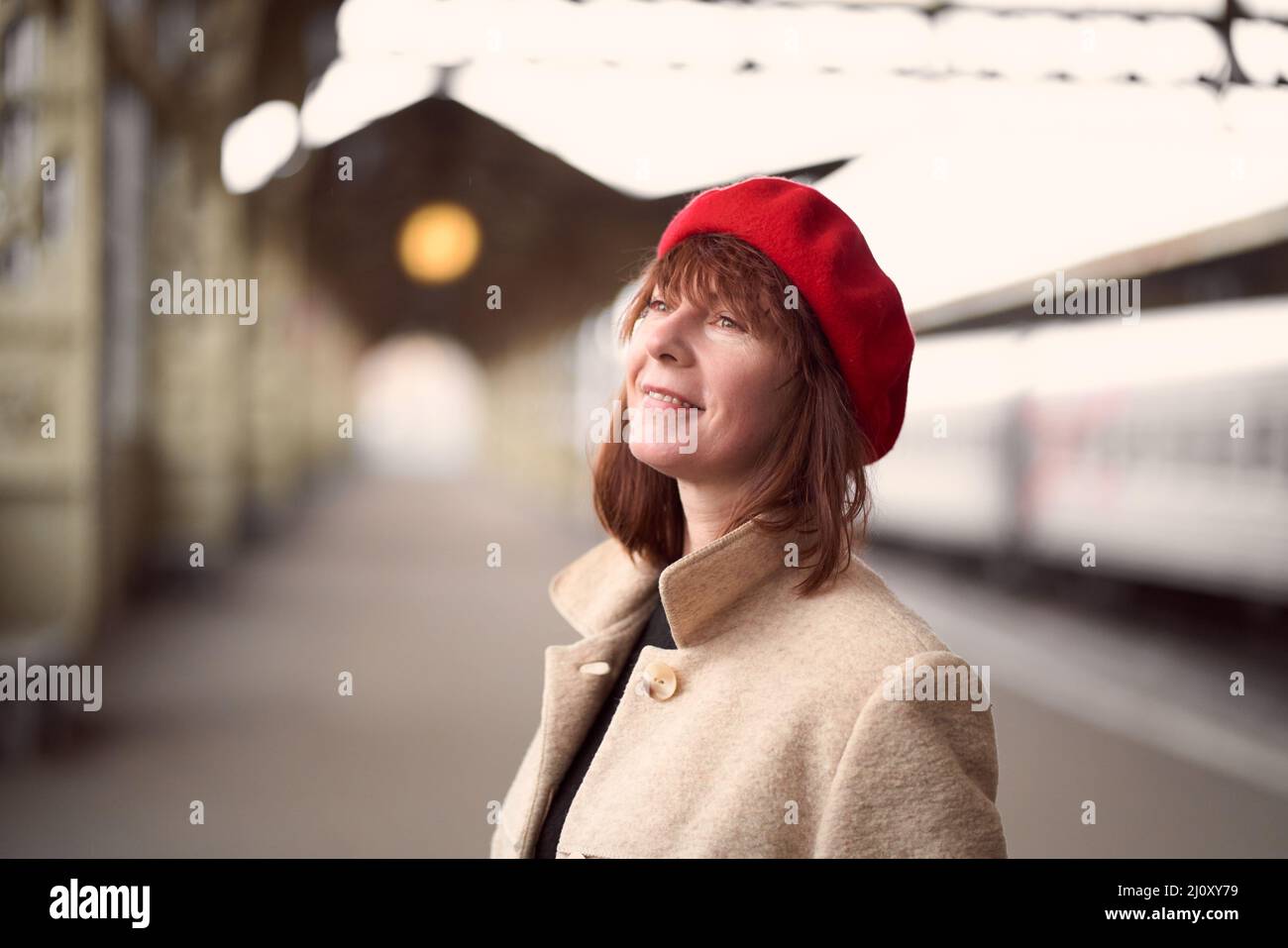 Primo piano ritratto di bella donna, in attesa di treno sulla stazione ferroviaria. La ragazza viaggia leggero. Foto Stock