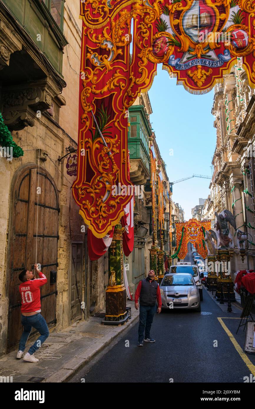 Stendendo striscioni per le strade, pronti per la festa del naufragio di San Paolo, Valletta, Malta Foto Stock