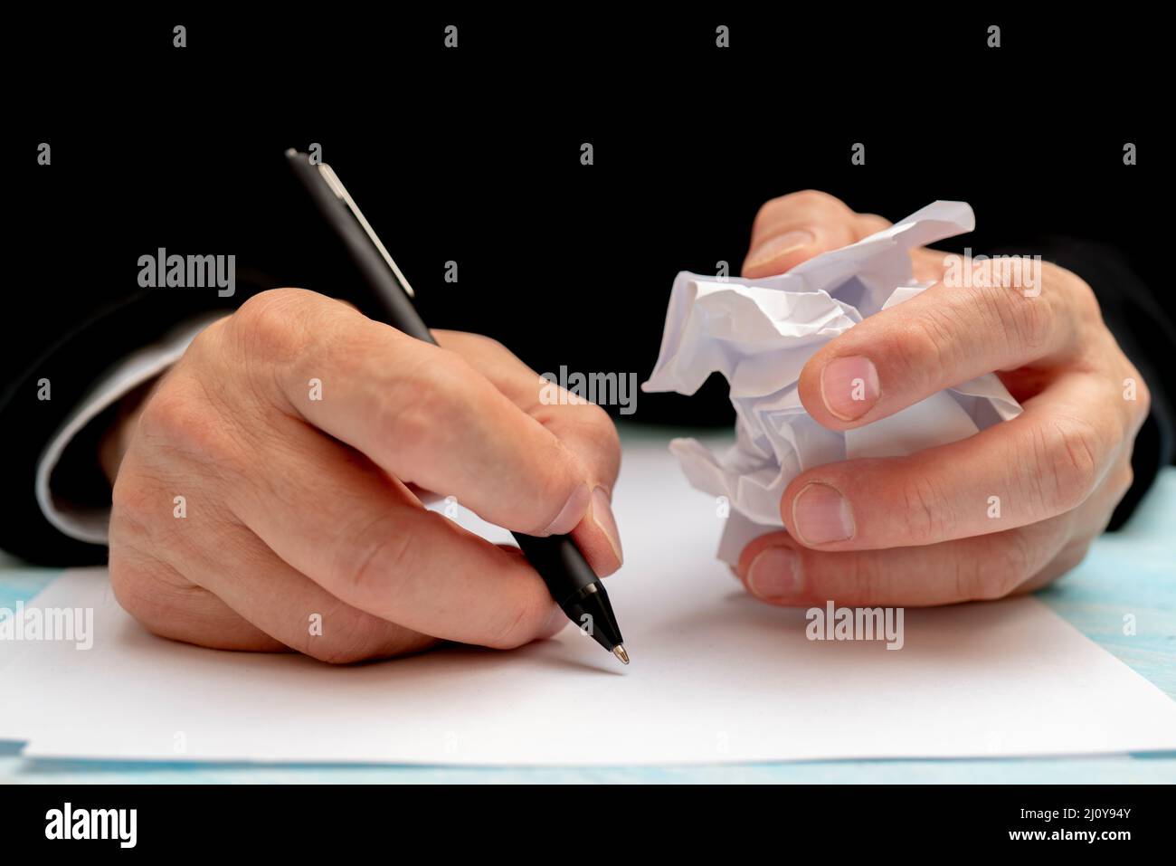 Una penna in una mano d'uomo. Foglio di carta bianco. La firma di un documento. Foto Stock