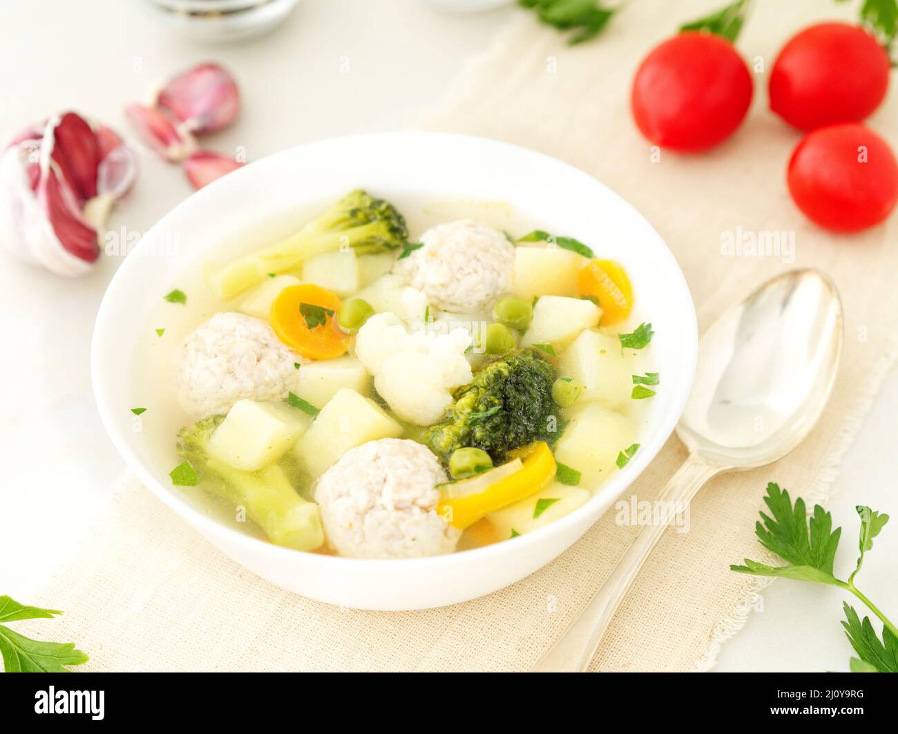 Ciotola di zuppa, una tazza di brodo e verdure, polpette di tacchino e pollo, vista laterale Foto Stock