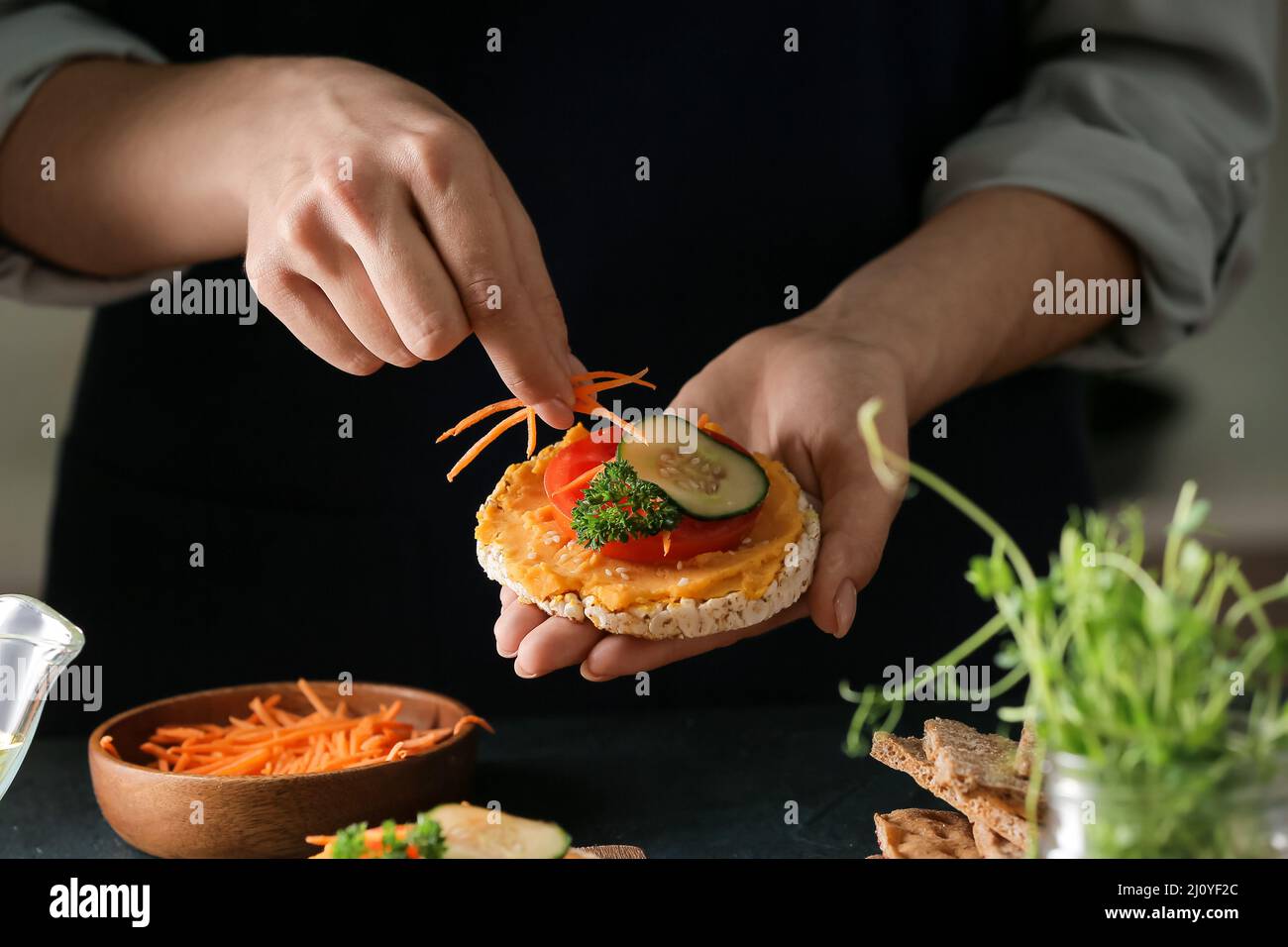 Donna che fa sandwich gustoso con hummus sano, primo piano Foto Stock