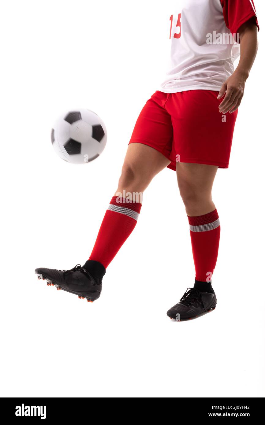 Sezione bassa del giovane femminile biraciale giocatore di calcio giocoleria palla di calcio con piede Foto Stock