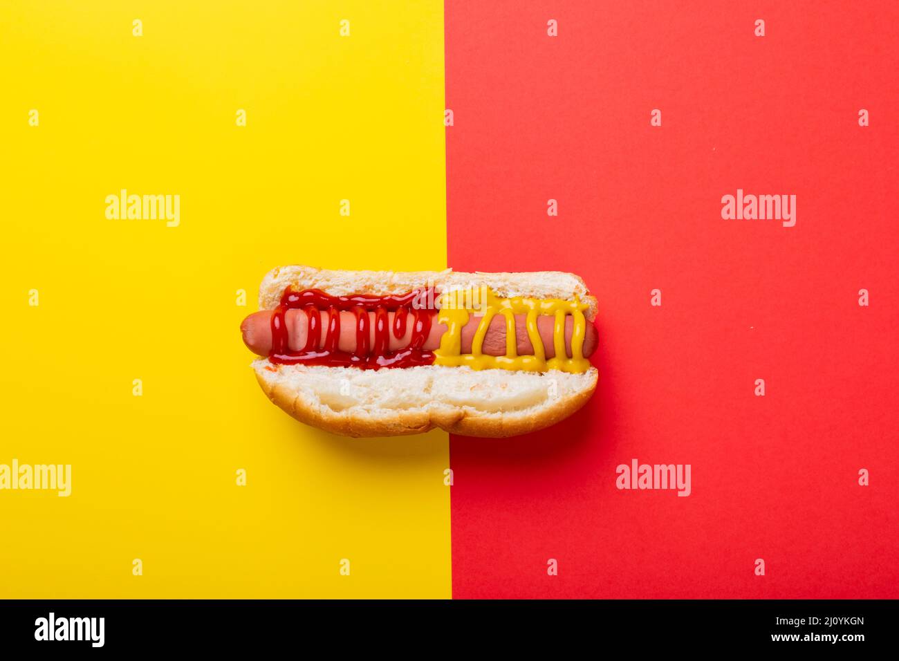 Hot dog con salsa di pomodoro e mostered su sfondo a due toni con spazio copia Foto Stock