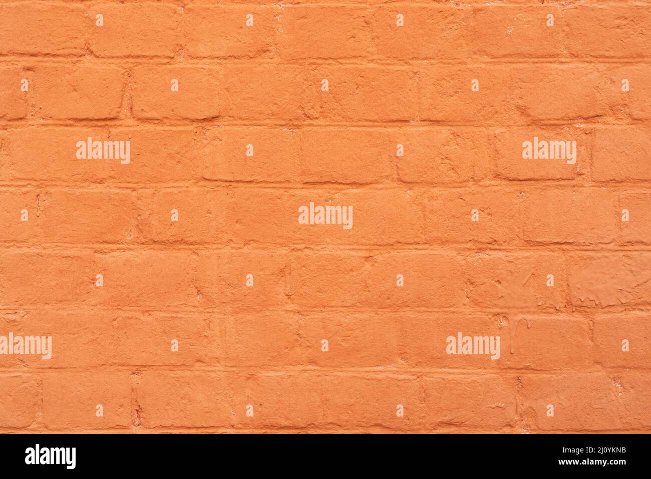 La parete in mattoni è dipinta con vernice arancione. Astratto sfondo architettonico. Foto Stock