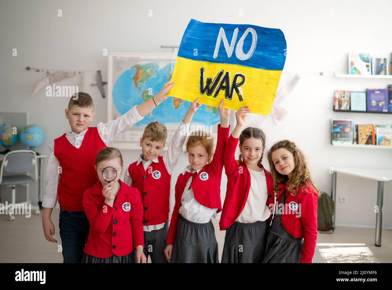 Scolari piccoli in vacanza e mostrando bandiera ucraina in classe, nessun concetto di guerra. Foto Stock