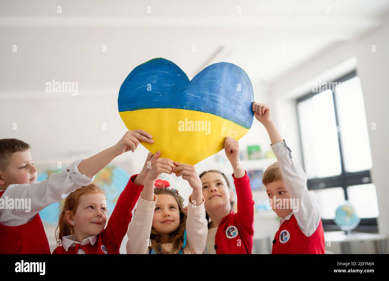 Piccoli scolari che si trovano in colori ucraini in classe, senza concetto di guerra. Foto Stock