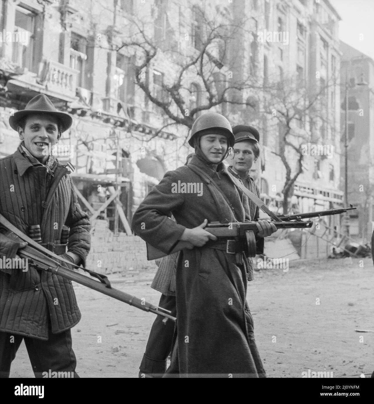 Rivoluzionari Ungheresi anticomunisti in mezzo agli edifici danneggiati di Budapest, novembre 1956. Foto Stock