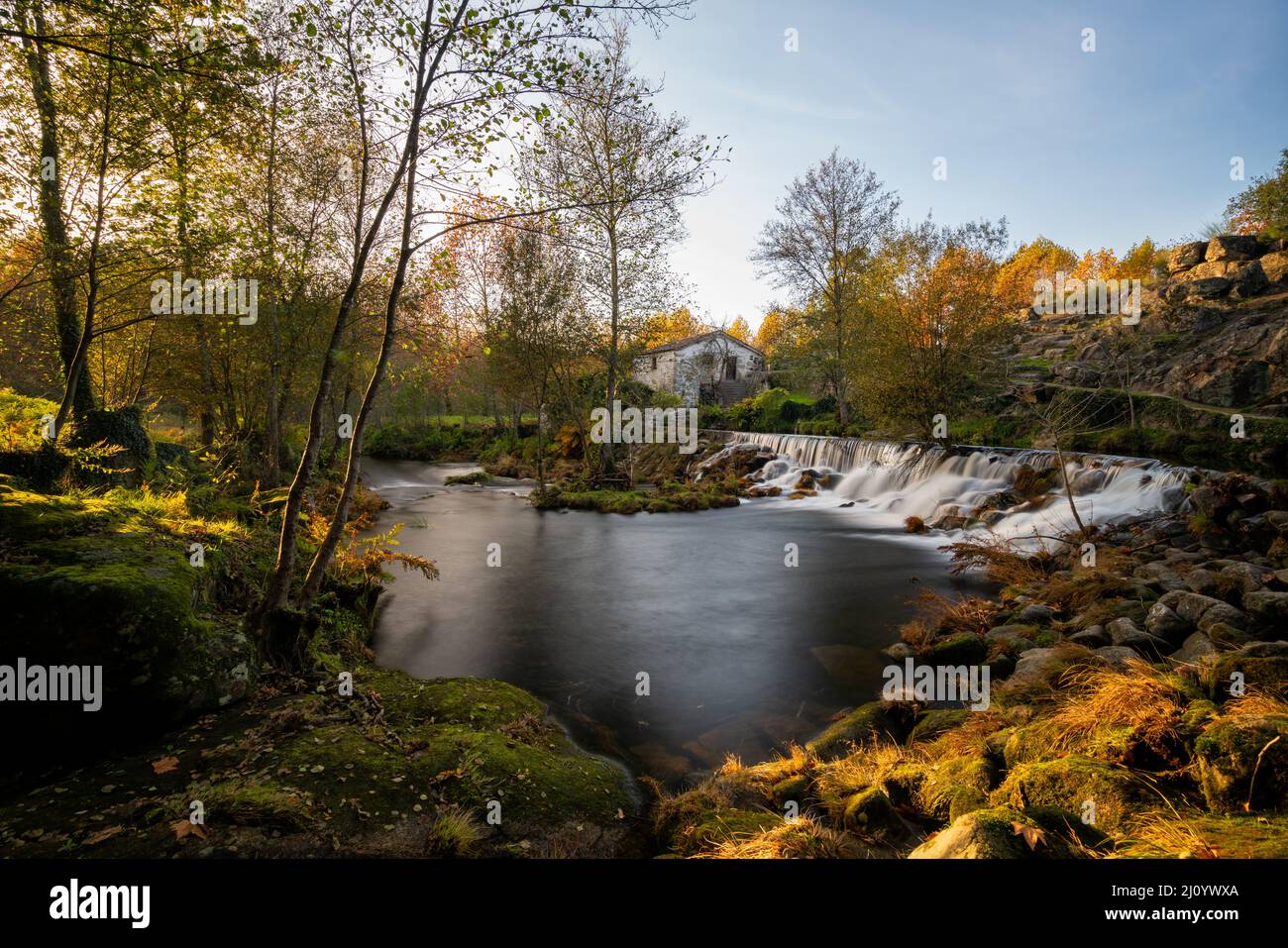 Cascata di Mondim de basso con una casa mulino al tramonto in Portogallo Foto Stock