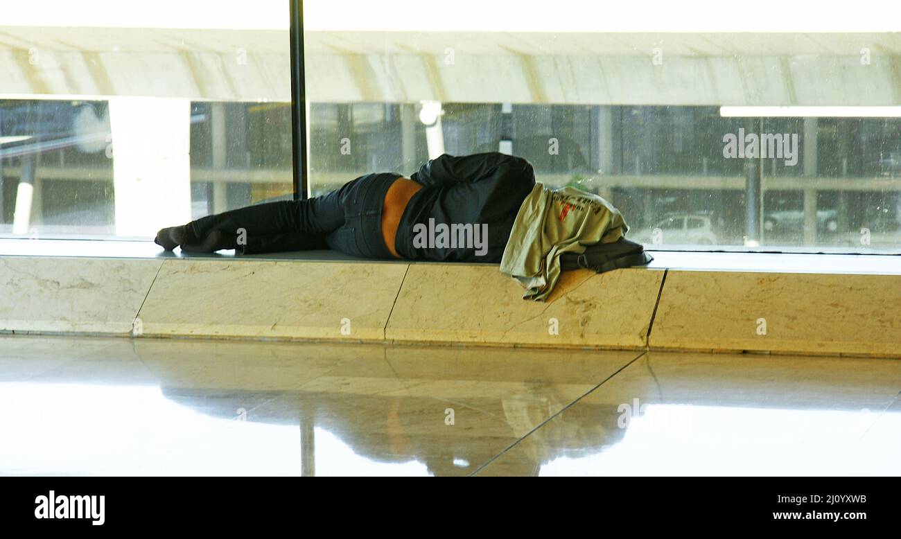 Uomo che dorme nel terminal 4 (T4) Madrid-Barajas, Spagna, Europa Foto Stock