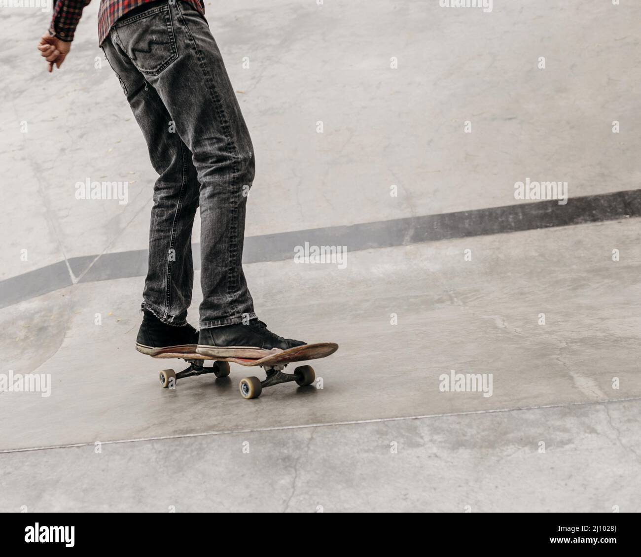 Uomo che si diverte con skateboard all'aperto parco cittadino Foto Stock