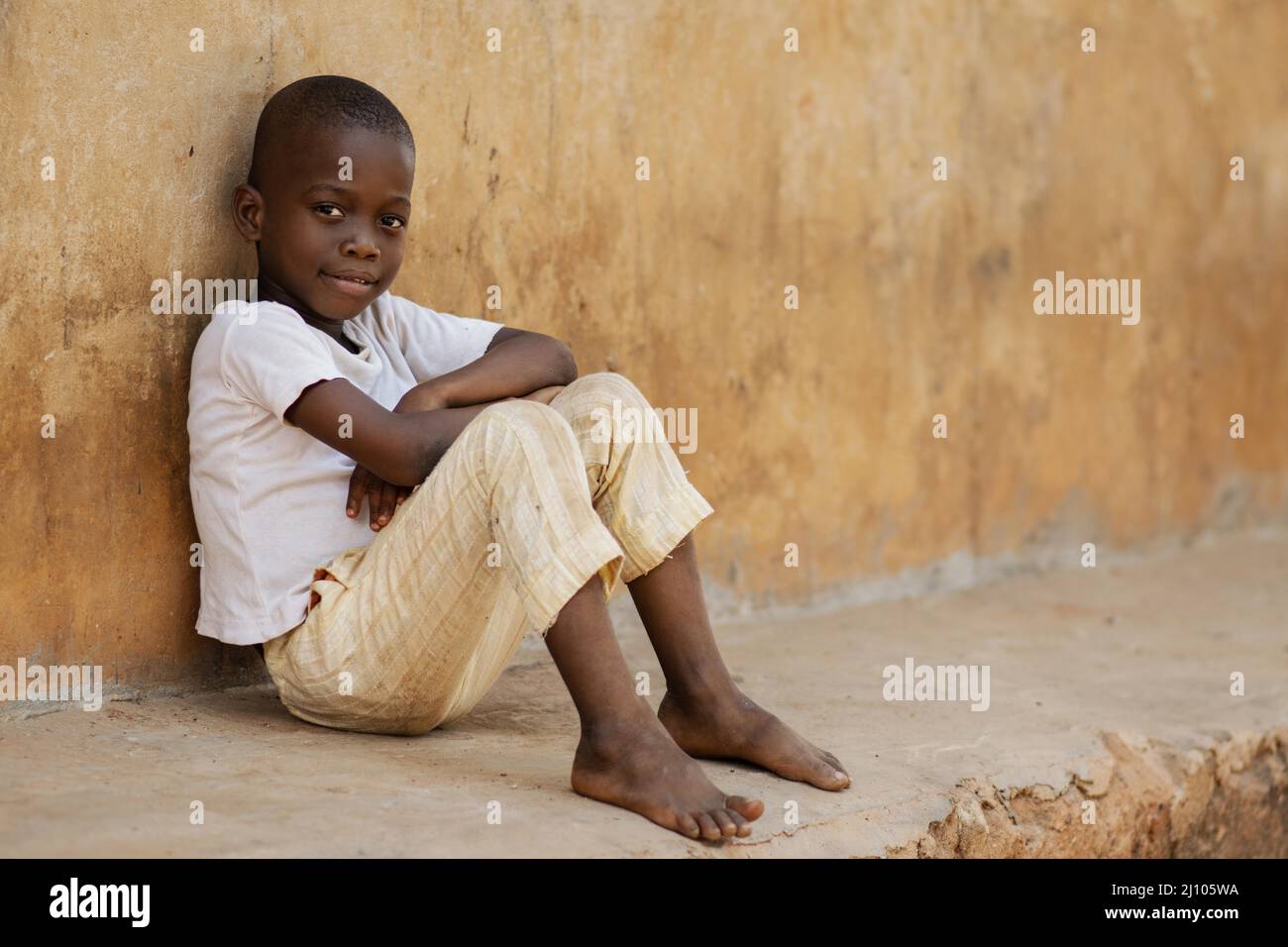 Bambino full shot seduto all'aperto Foto Stock