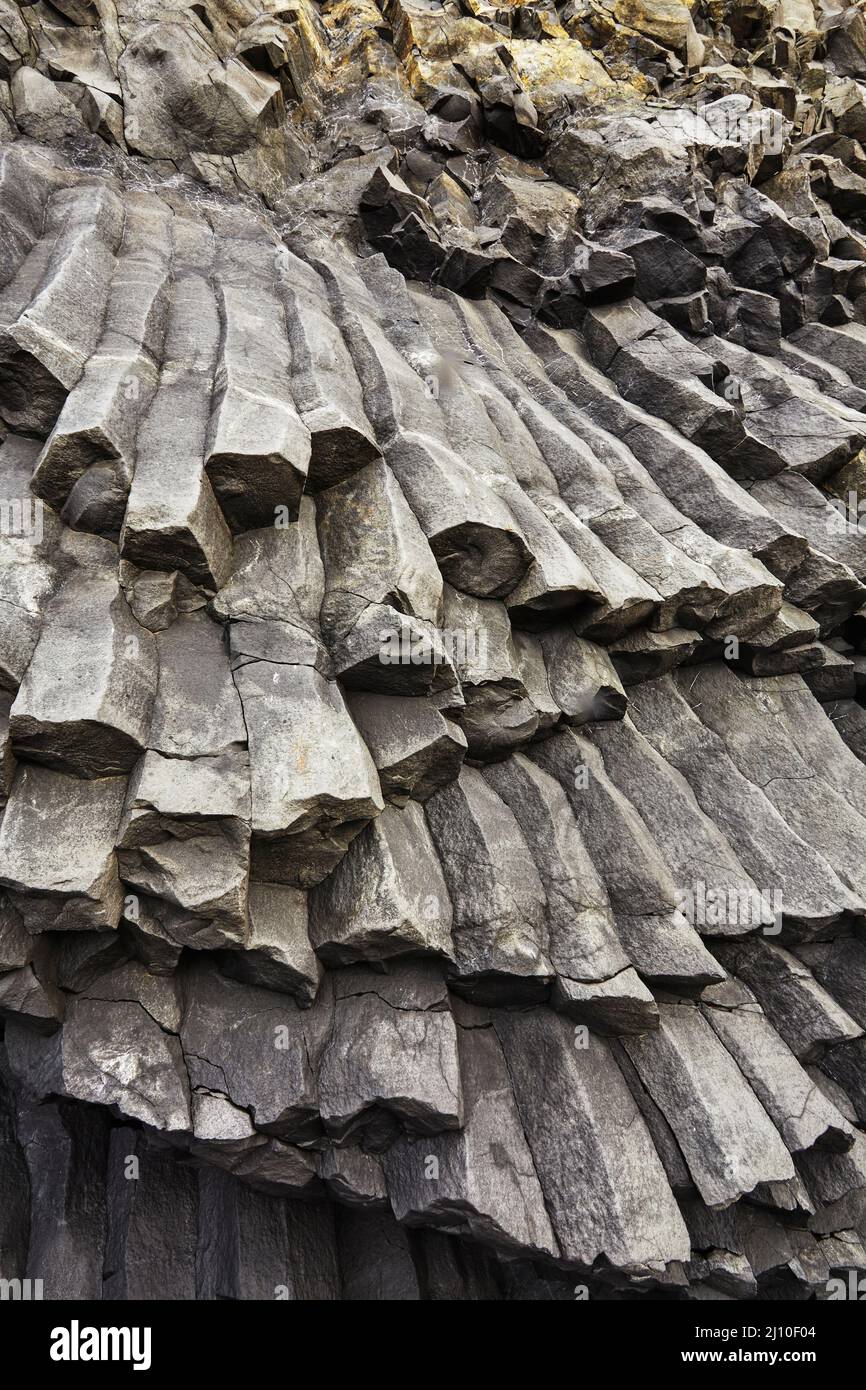 Colonne di rocce create dalla lava basaltica, nelle scogliere costiere della spiaggia di Reynisfjara, vicino a Vik, costa meridionale dell'Islanda. Foto Stock