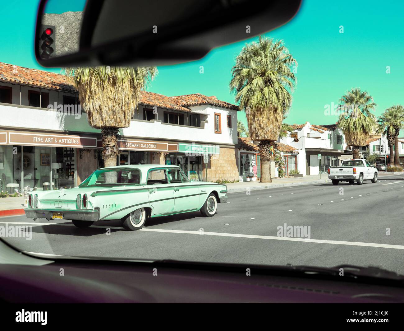Berlina americana degli anni '60 che guida lungo una strada a Palm Springs California USA Foto Stock