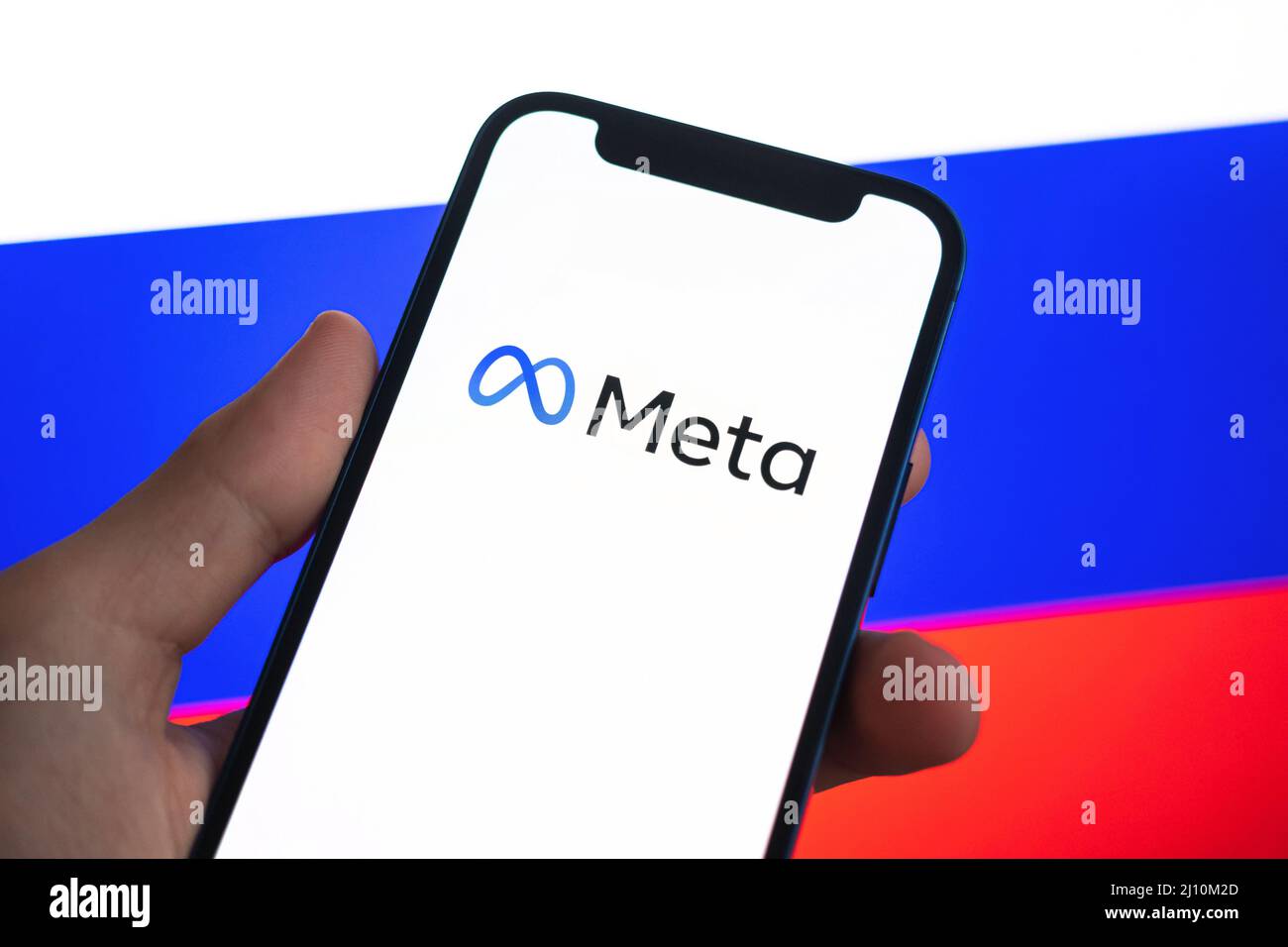 Poltava, Ucraina - 21 marzo 2022: Meta in Russia. Nuovo logo Facebook contro l'immagine di sfondo della bandiera russa. Azienda bloccata e vietata Foto Stock