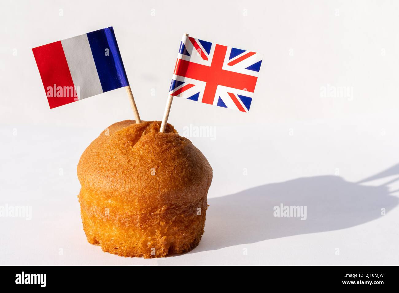 Cupcake fatto in casa con bandiere di Regno Unito e Francia su sfondo bianco, spazio copia. Il concetto di cooperazione tra paesi. Il concetto di relazione commerciale Foto Stock