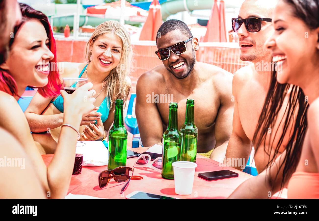 Amici multiculturali alla moda divertirsi bevendo birra durante le vacanze estive - concetto di viaggio stile di vita con i giovani che tostano bottiglie di birra di lusso Foto Stock
