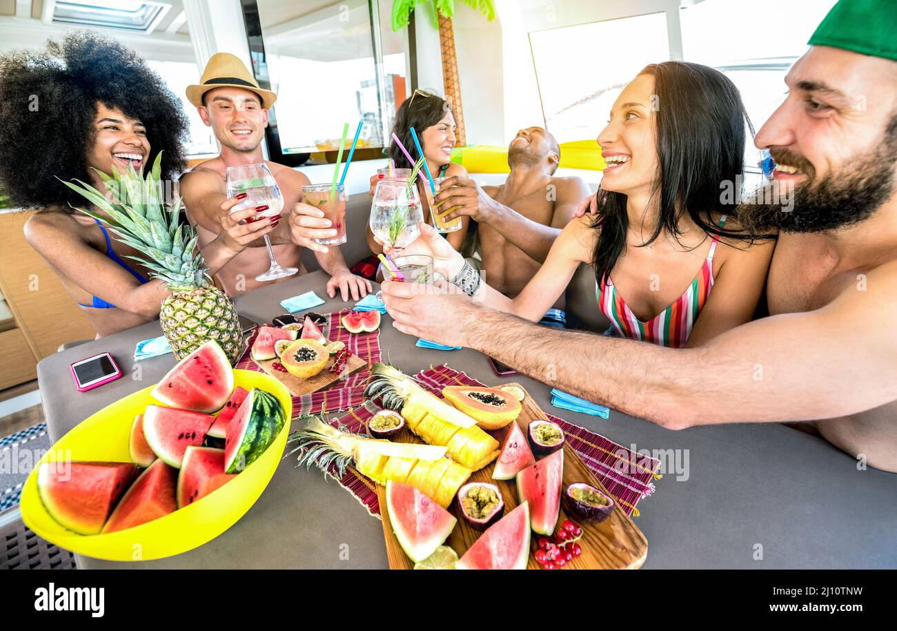 Amici felici che bevono cocktail di fantasia durante il viaggio di festa in barca - giovani milleniali persone che si divertono in vacanza di lusso - concetto di stile di vita di viaggio con mille Foto Stock