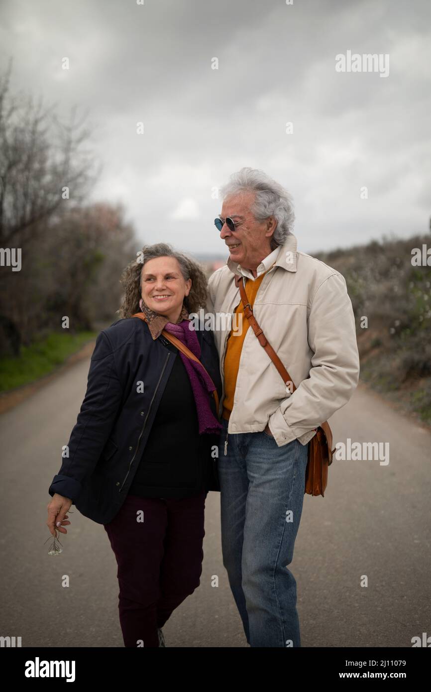 Una coppia, uomo e donna, coppia in pensione, 60 e 70 anni, con capelli grigi, godere di una romantica passeggiata in primavera, in una zona rurale del campo de Borja, Foto Stock