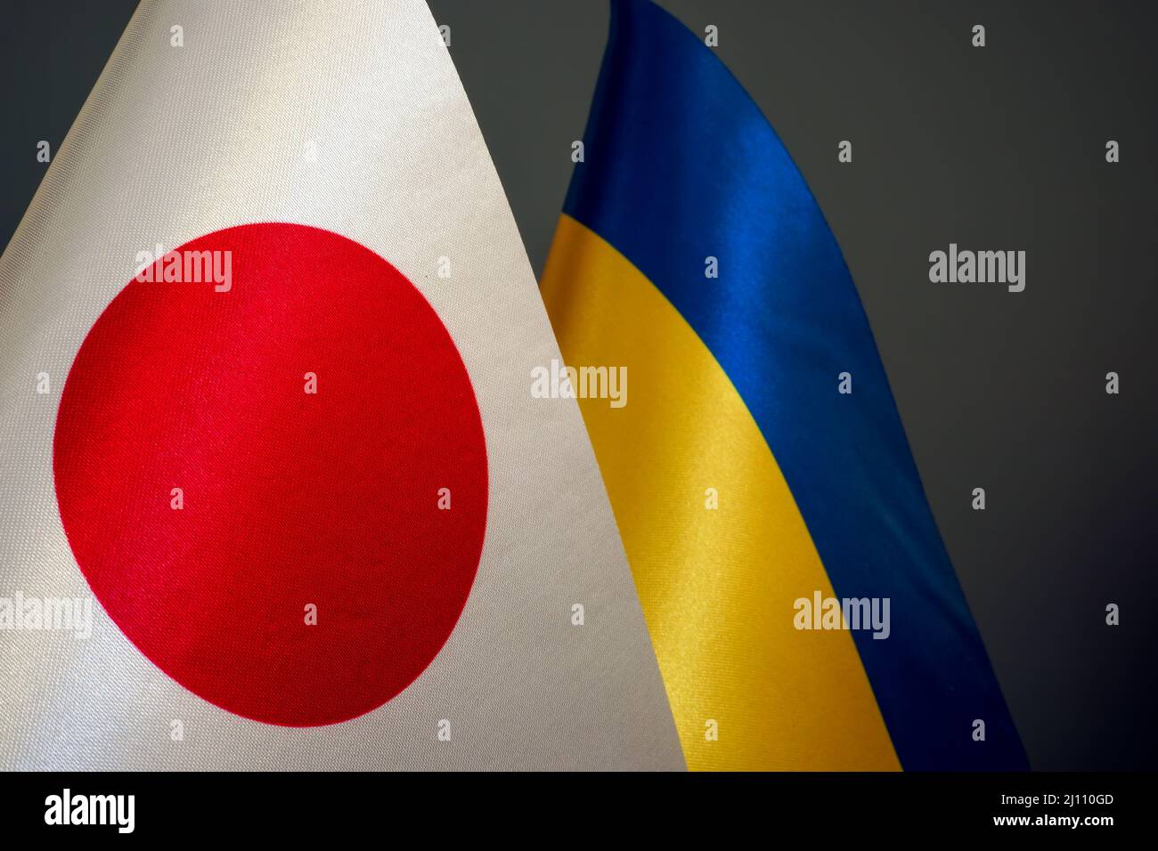 Bandiere di Ucraina e Giappone su sfondo scuro. Foto Stock