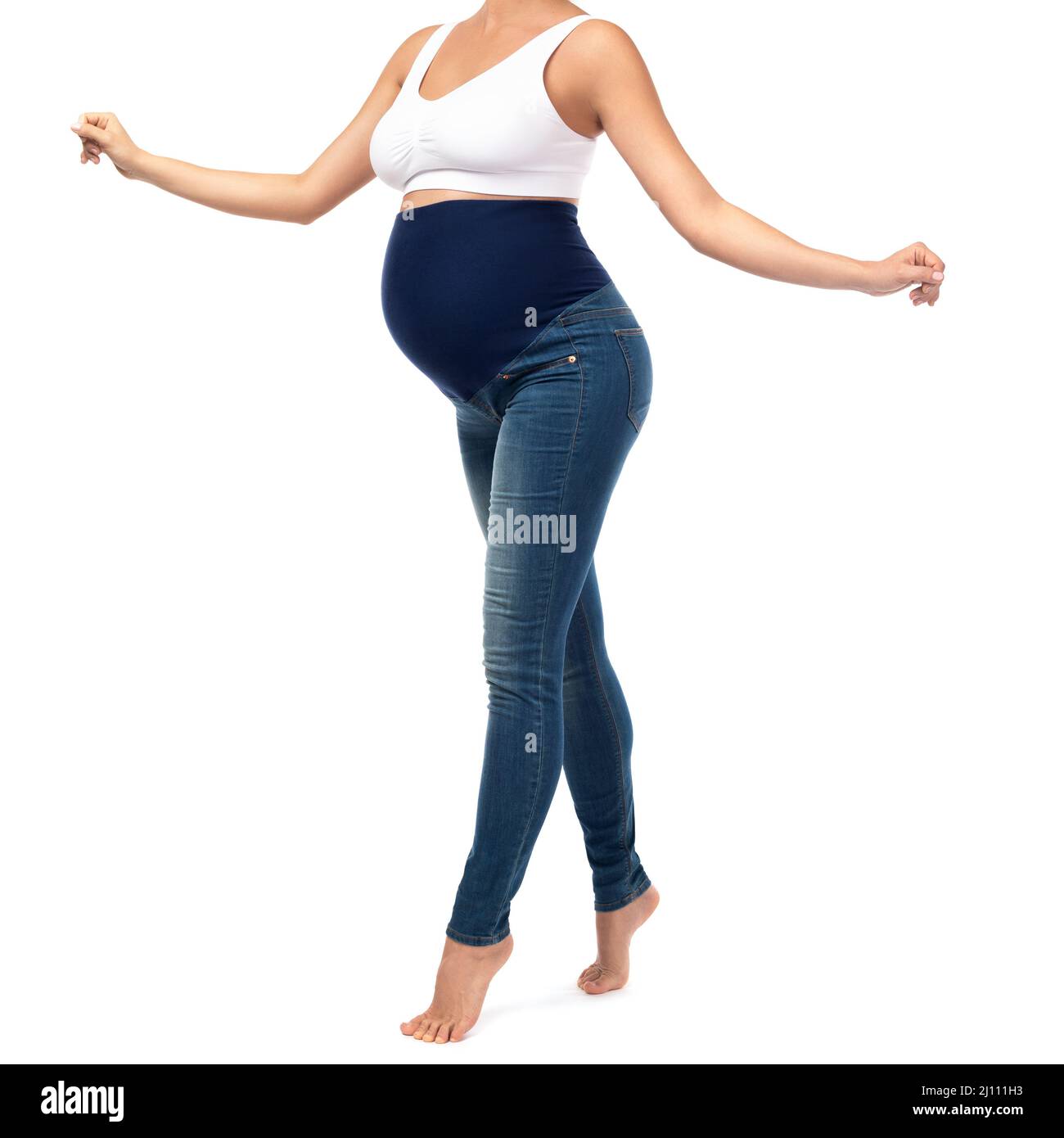 Donna giovane e incinta che indossa jeans per maternità Foto stock - Alamy