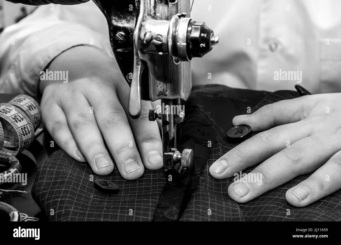 Tailor's hands close-up cucire abiti su una vecchia macchina da cucire retrò. Strumenti per un sarto, stilista di moda o marinaio Foto Stock