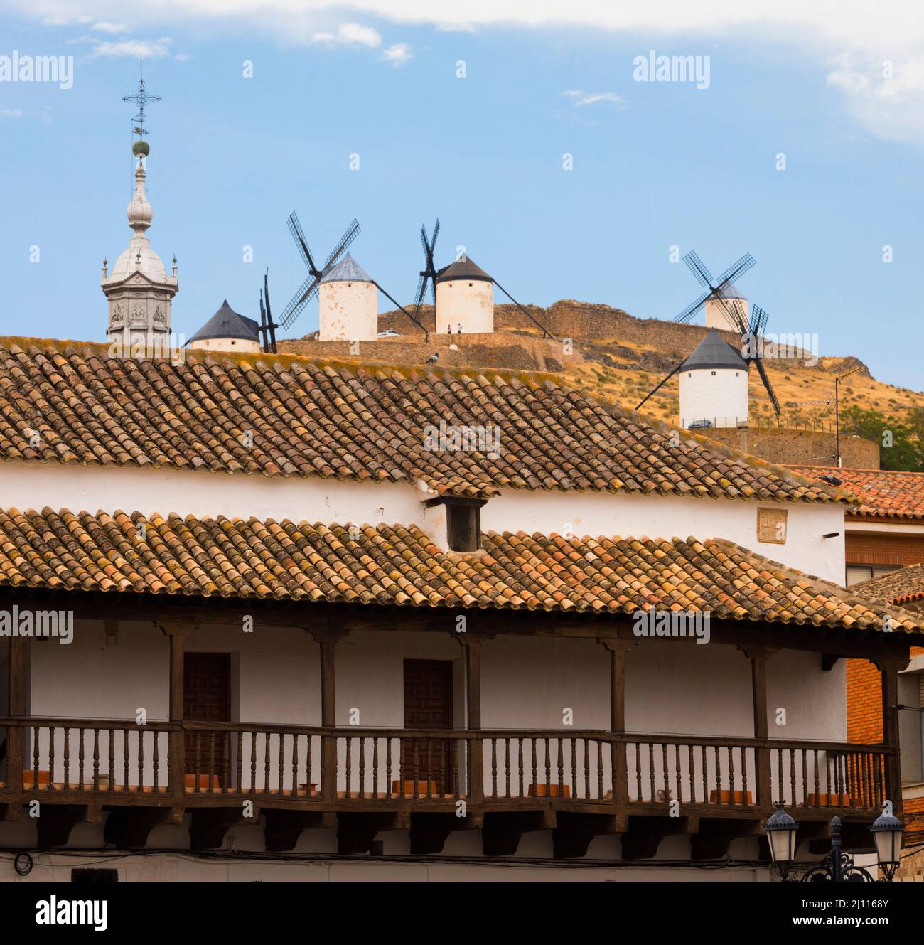 Consuegra, provincia di Toledo, Castilla-la Mancha, Spagna. Mulini a vento visti dalla piazza principale, Plaza de Espana. L'edificio è conosciuto come Los Corredores Foto Stock