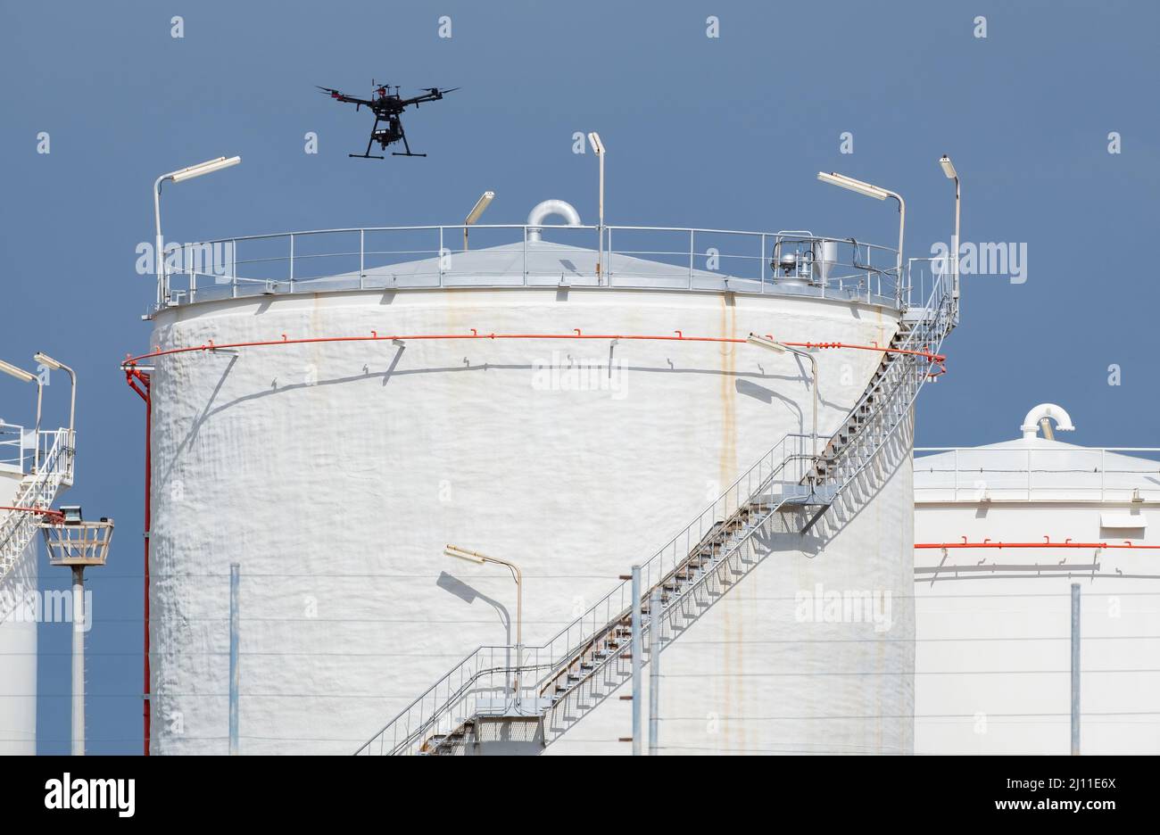 Drone che vola su serbatoi di stoccaggio carburante/gas in raffineria. Attacco con droni, carburante, prezzi del gas, Foto Stock