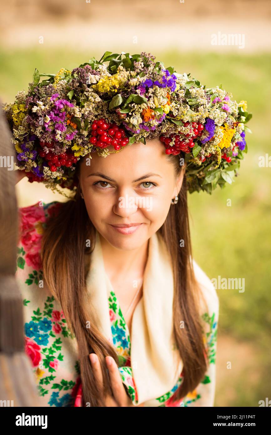 Giovane graziosa donna ucraina con una corona di erbe secche sulla testa Foto Stock