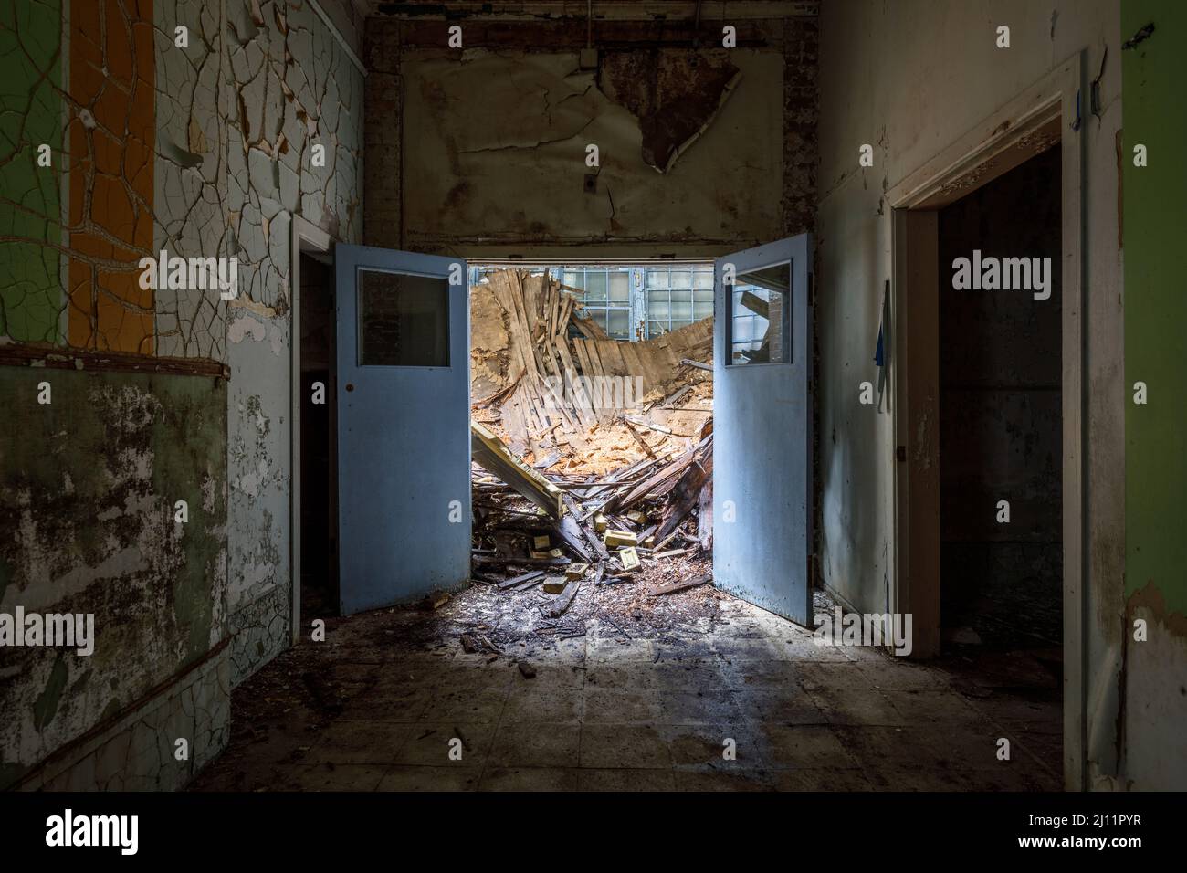 Guardando attraverso una porta ad un edificio parzialmente crollato. Foto Stock
