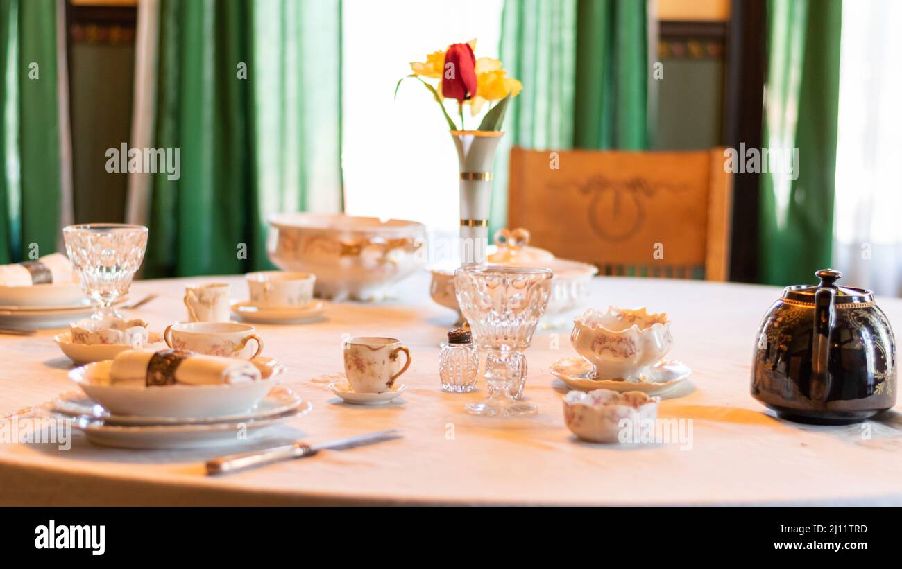 Tavolo con antico porcellana set, vetri di cristallo, e panno da tavolo bianco al Riordan Mansion a Flagstaff, Arizona, U.S.A. Foto Stock