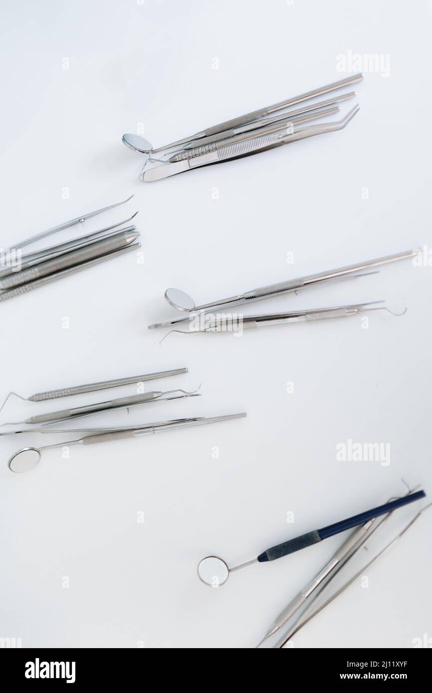 Vista dall'alto di varie apparecchiature dentistiche organizzate su sfondo bianco Foto Stock