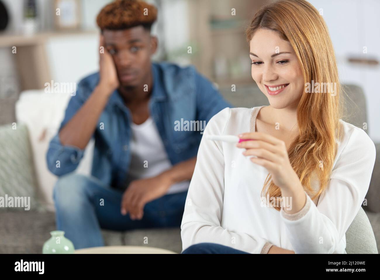 uomo preoccupato che controlla un test di gravidanza Foto Stock