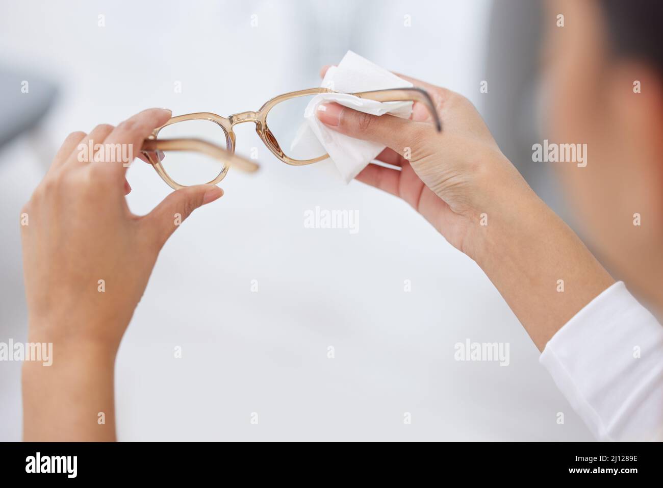 La mia visione non è mai stata più chiara. Shot di una donna che pulisce un paio di occhiali. Foto Stock