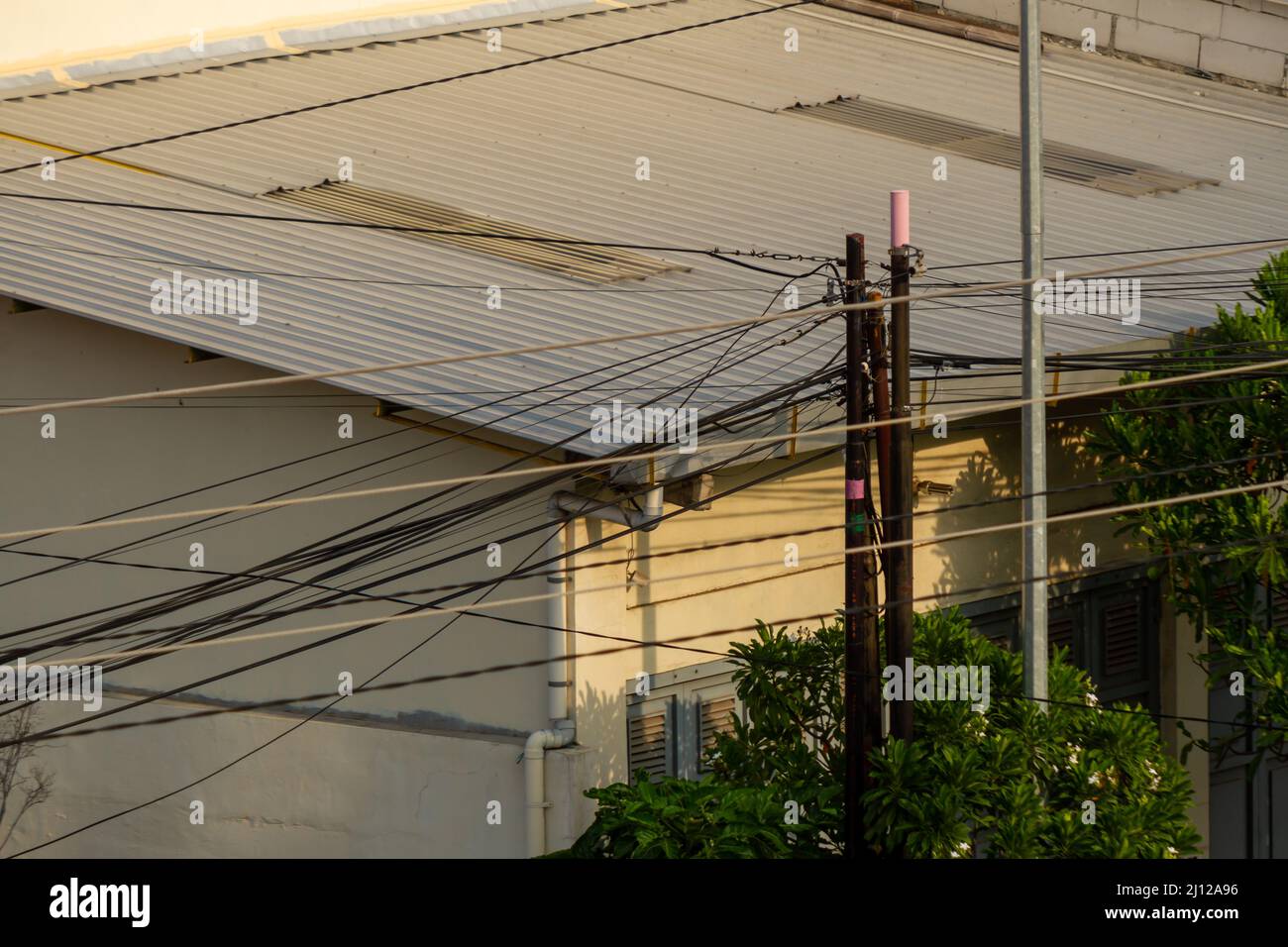 Il cablaggio per le reti elettriche e di comunicazione sembra caotico e disorganizzato, creando nuovi problemi, tra bisogno, pericolo e stress Foto Stock