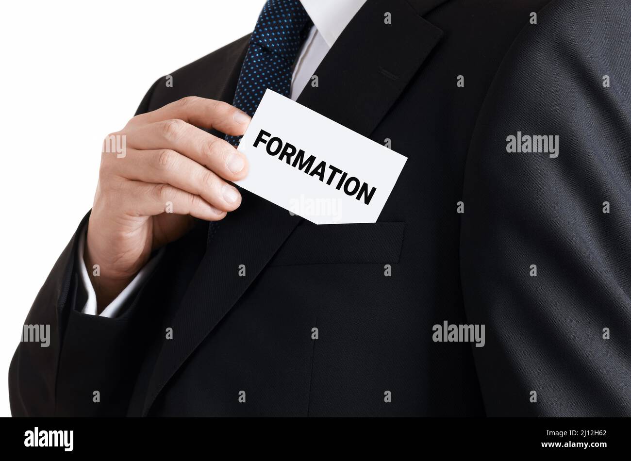 L'uomo d'affari toglie un biglietto da visita dalla sua tasca con la formazione della parola. Concetto di formazione, sviluppo e competenze professionali. Foto Stock