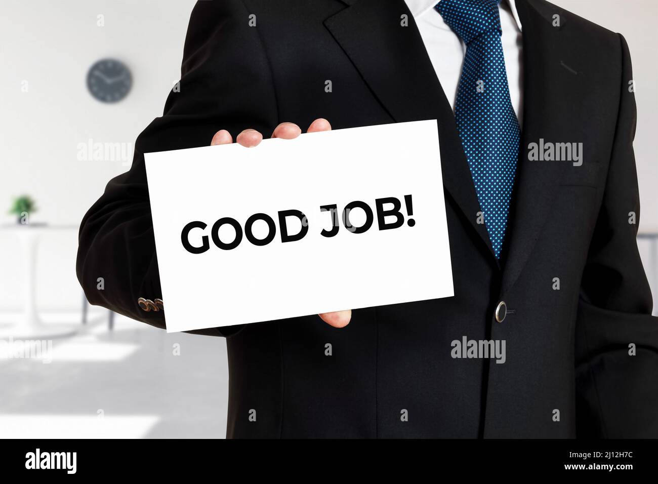 L'uomo d'affari tiene una scheda con il buon lavoro del messaggio. Concetto di business per la valutazione del successo Foto Stock